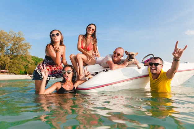 Happy company of friends on summer tropical vacation in Thailand traveling on boat in sea, party on beach, people having fun together, men and women positive emotions