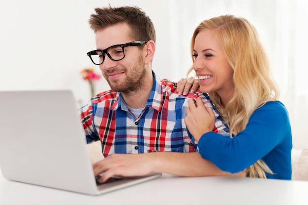 Free photo happy couple browsing something on laptop