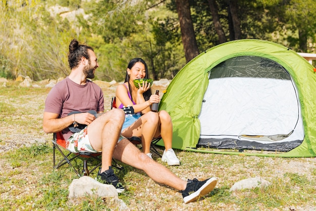 Free photo happy couple camping in forest