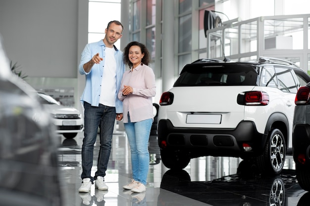 Happy couple in car showroom dealership