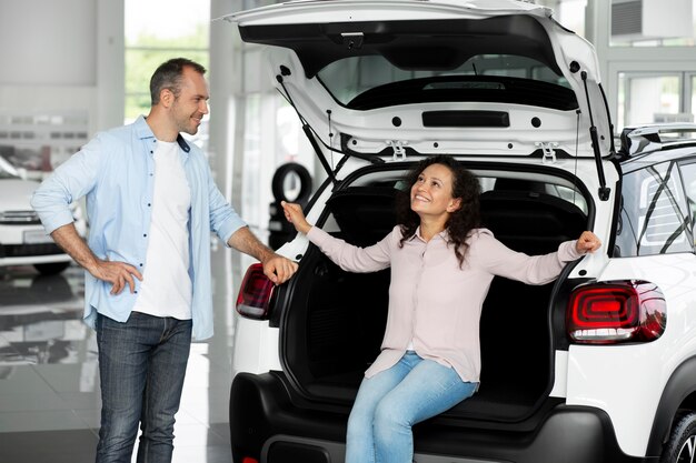 Happy couple in car showroom dealership