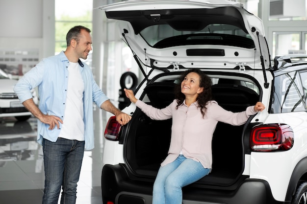 Happy couple in car showroom dealership