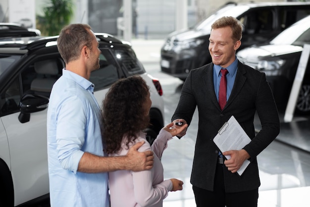 Happy couple in car showroom dealership