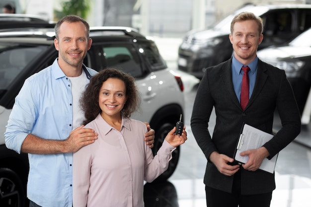 Happy couple in car showroom dealership