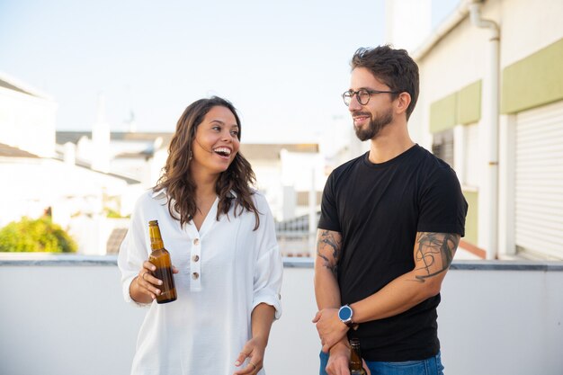 Happy couple chatting, laughing and drinking beer