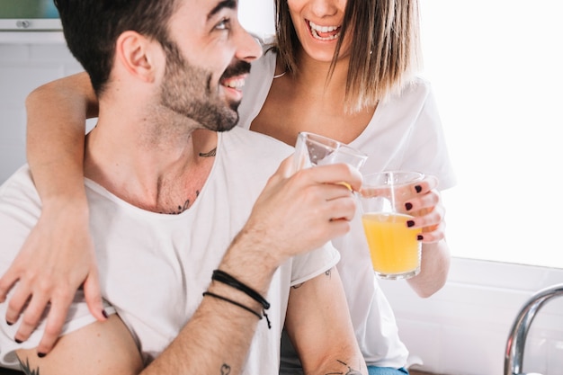 Free photo happy couple clinking glasses in kitchen