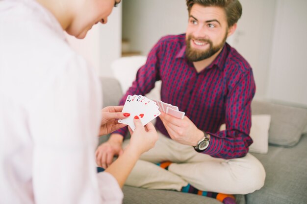 Happy couple on couch playing card game