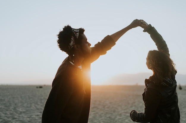 Free photo happy couple dancing at the beach