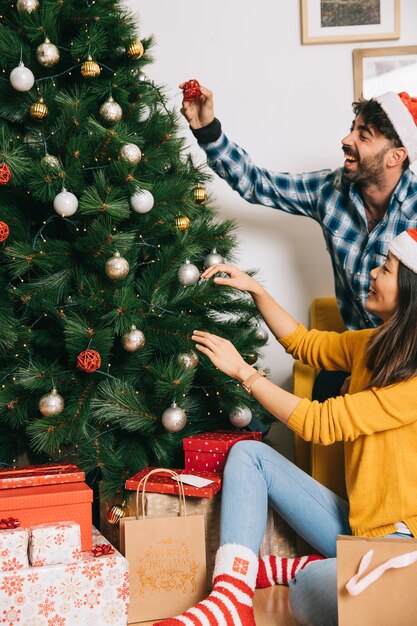 Happy couple decorating christmas tree