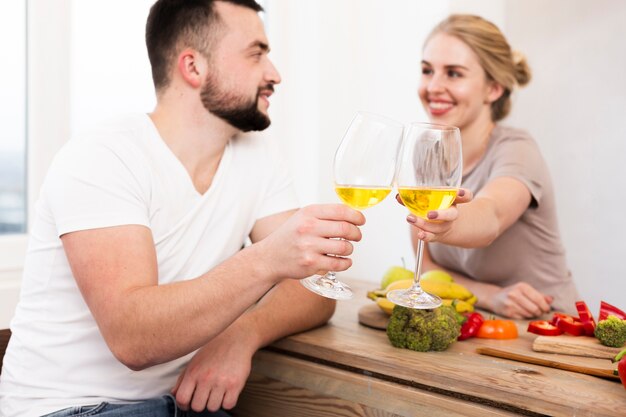 Happy couple eating vegetables and drinking together