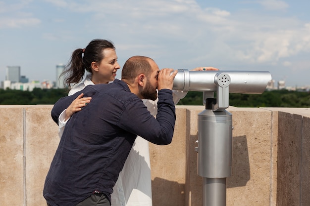 Happy couple enjoying summer spending time on building tower