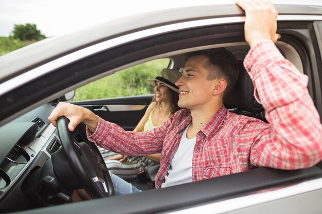 Happy couple enjoying travelling in the car