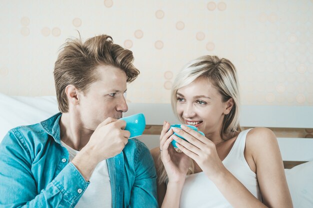 Happy couple hand holding cup and drinking coffee in the morning