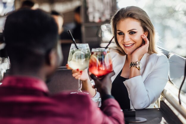 Free Photo happy couple having tender moments and drinking cocktails in lounge bar - young lovers having fun dating in luxury club hotel.