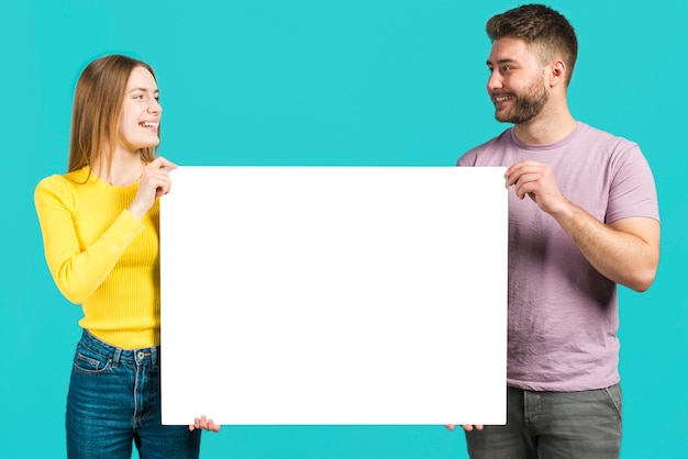 Happy couple holding blank sign