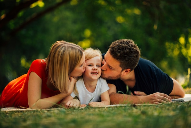 Free photo happy couple kissing their child