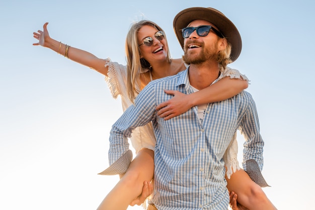 happy couple laughing traveling in summer by sea, man and woman wearing sunglasses