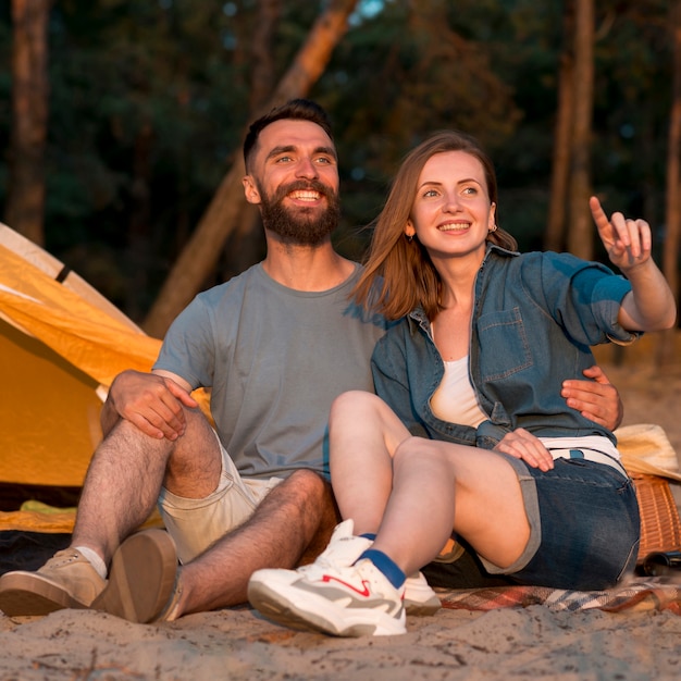 Happy couple looking away by tent