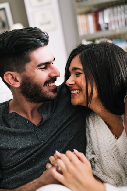 Happy couple looking at each other holding hands