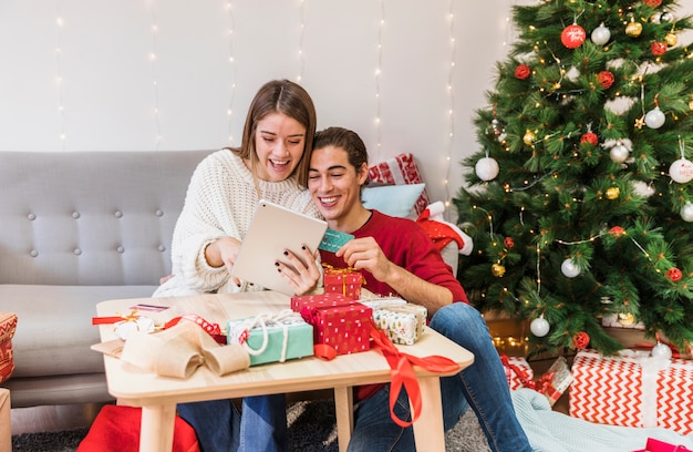 Happy couple looking at tablet on couch