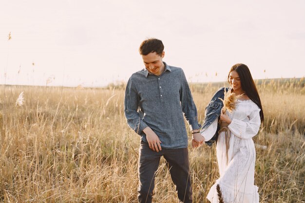 Happy couple in love in wheat field at sunset