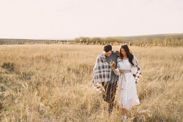 Happy couple in love in wheat field at sunset