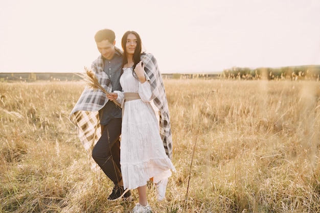 Happy couple in love in wheat field at sunset