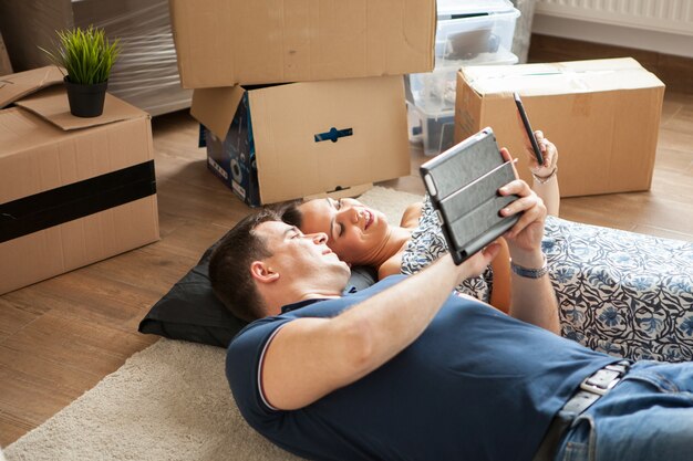 Happy couple lying on the floor after moving in .Woman and man smiling