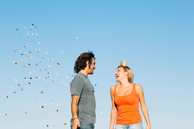 Happy couple near falling confetti