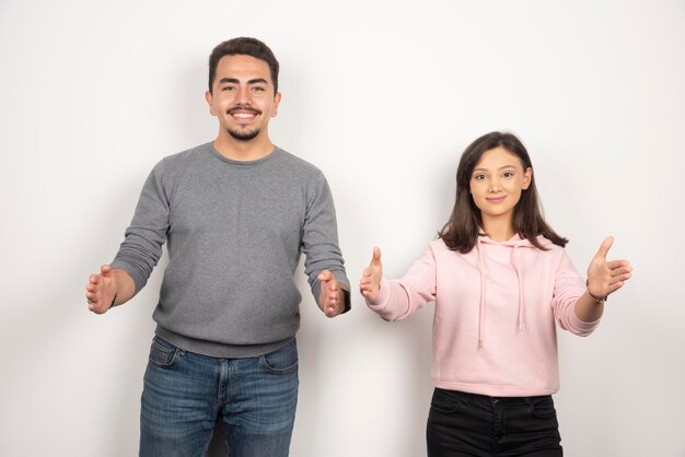 Happy couple posing against white.