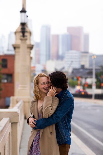 Happy couple posing outdoors in the city with engagement ring