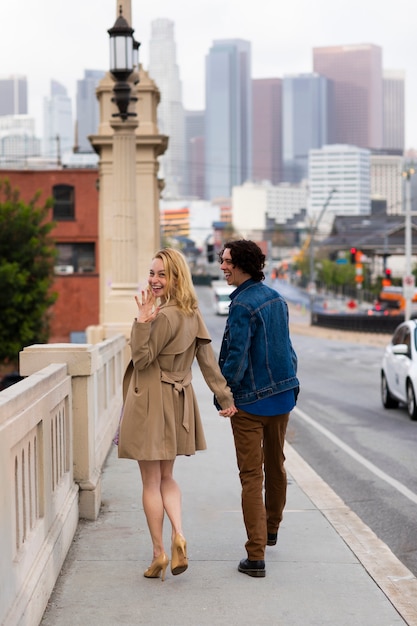 Happy couple posing outdoors in the city with engagement ring