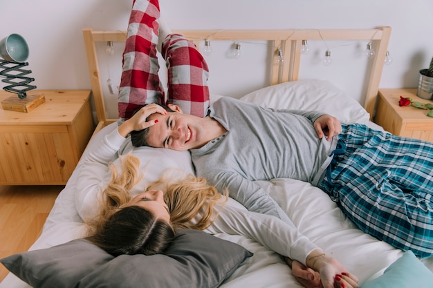 Happy couple resting on bed