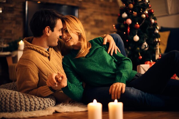 Happy couple showing affection while relaxing on Christmas eve at home