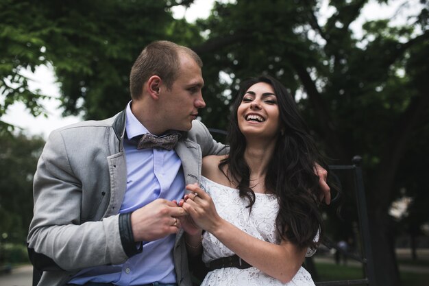 Happy couple sitting on a bench in the park