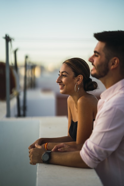 Happy couple standing in the balcony and having some romantic time together