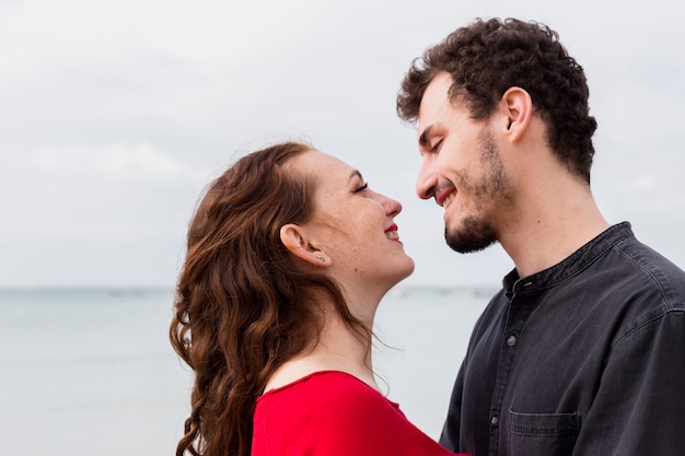 Happy couple standing on sea shore 