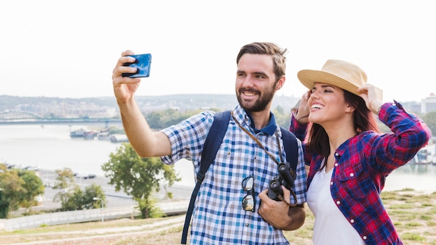 Free photo happy couple taking selfie on smartphone at outdoors