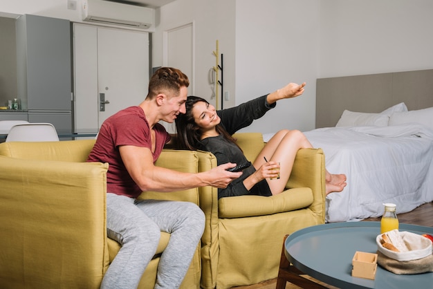 Happy couple watching tv at home