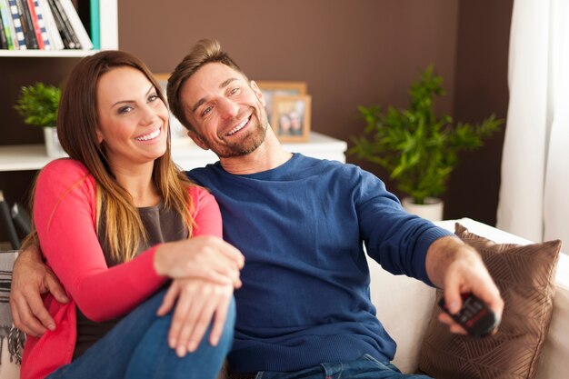 Happy couple watching tv at home