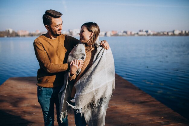 Happy couple with blanket by the river