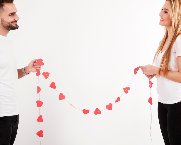 Free photo happy couple with heart garland