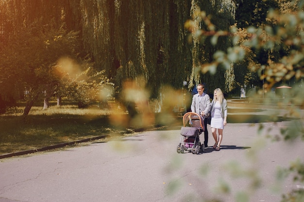 Free photo happy couple with stroller in the park