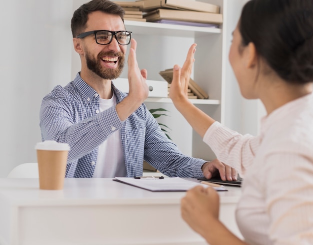 Happy coworkers celebrating with high five