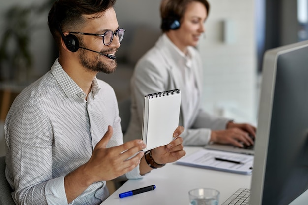 Free Photo happy customer service representative using computer and having video call with clients while working at call center