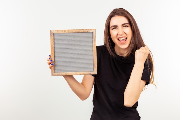 Happy cute lady holding board and raising her fist