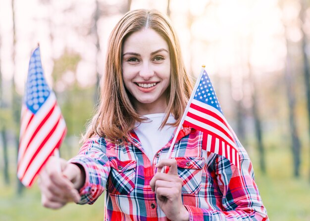 Happy cute young woman with American flags