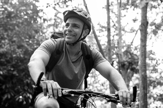 Happy cyclist riding through the forest