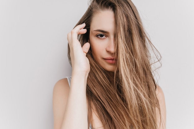 Free photo happy dark-eyed girl posing in morning. shot of enchanting caucasian female model touching her dark hair.