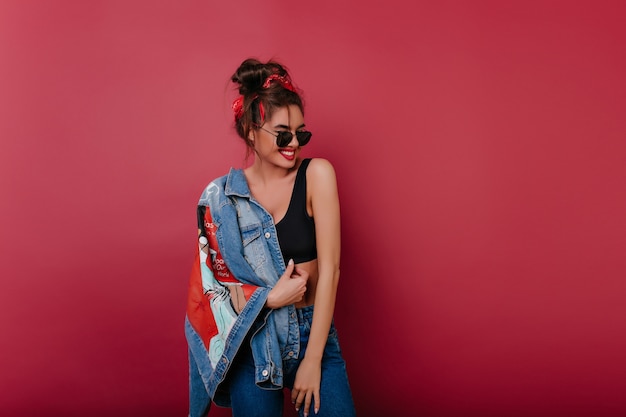 Free photo happy dark-haired woman wears denim clothes spending time on photoshoot